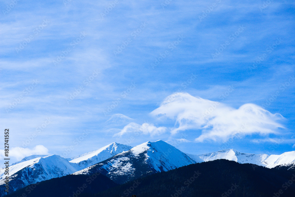 Mountain snow peak, beautiful natural winter backdrop. Ice top of the hill, blue sky background. Alpine landscape.