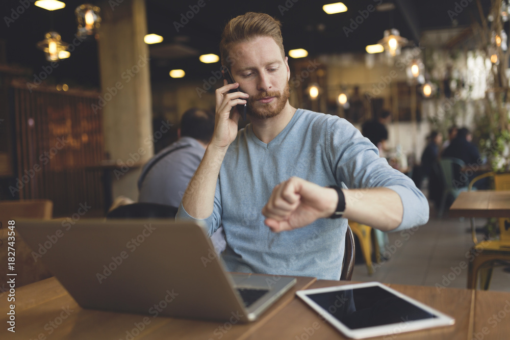 Young busy man having phone call in cafe Young busy man having phone call in cafe