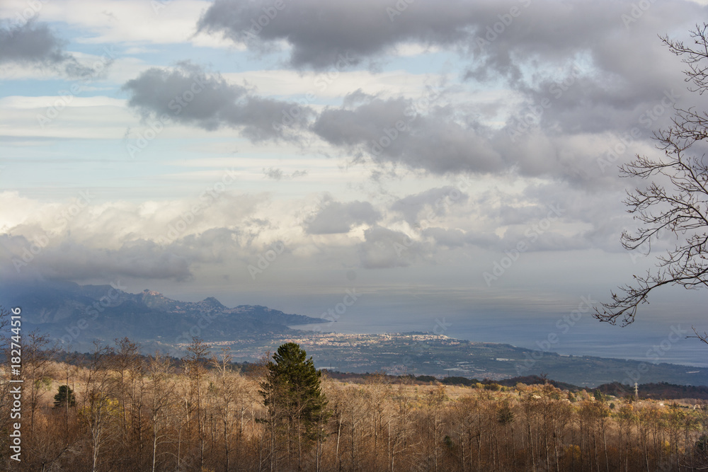 Lava soil from Etna volcano in the background on the left Taormina