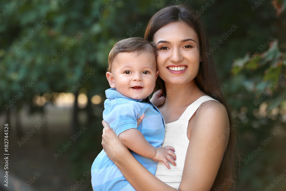 Beautiful young mother holding cute baby boy, outdoors Beautiful young mother holding cute baby boy, outdoors