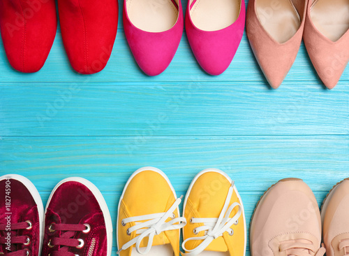 Various female stylish shoes on wooden background