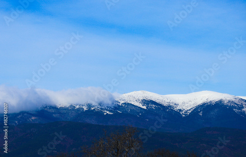 Mountain snow peak  beautiful natural winter backdrop. Ice top of the hill  blue sky background. Alpine landscape.