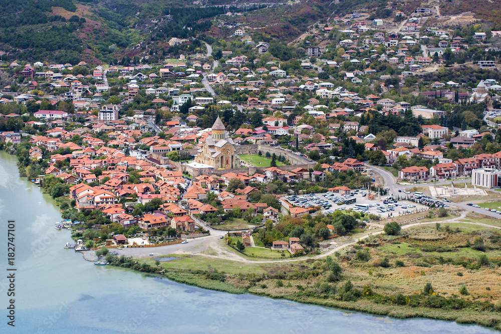 Ancient town with red roofs, cathedral in the middle and blue water.