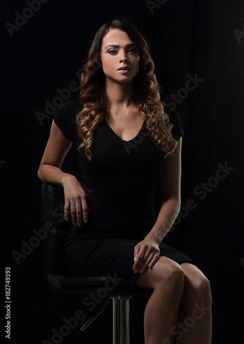 young gorgeous caucasian brunette in dress on chair