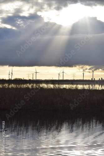 Landscape with windmills and sun beams on autumn day