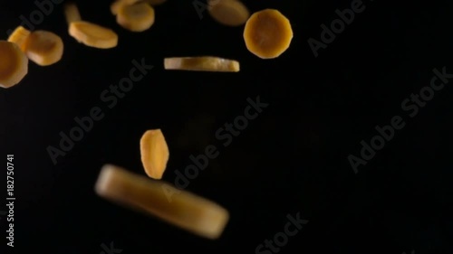 falling carrot slices on a black background. macro photo