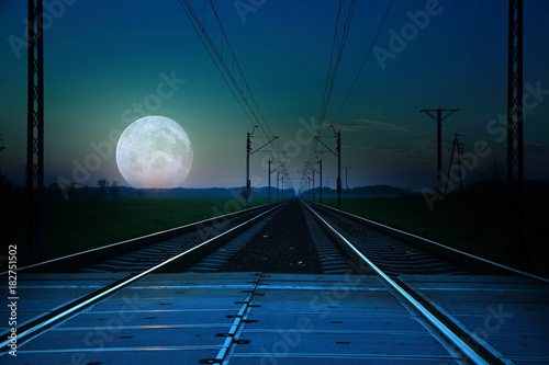 Tory kolejowe i księżyc w pełni o zmierzchu. © Stanisław Błachowicz