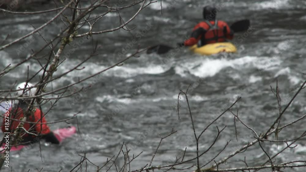Group of unrecognizable people kayak down river rapids in Oregon during autumn after heavy rain. Group of unrecognizable people kayak down river rapids in Oregon during autumn after heavy rain.