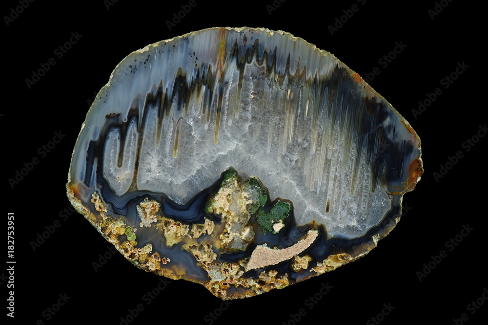A cross section of the agate stone. Multicolored silica bands colored with metal oxides are visible. Stalactite agate filled with quartz. Origin: Rudno near Krakow, Poland.
