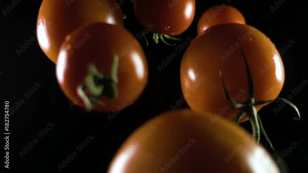 falling tomato on a isolate on black background falling tomato on a isolate on black background