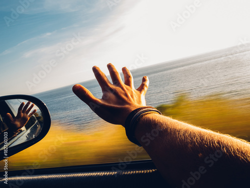 roadtrip moment - während der auto fahrt ausgestreckter arm aus dem fenster photo