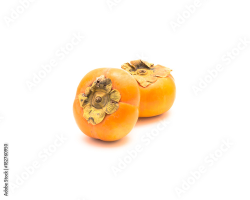 Two ripe Fuyu persimmon isolated on white background. Fresh raw non-astringent persimmon (kaki fruit)  is squat like a tomato. Diospyros Japanese cultivar close-up with clipping path and copy space. photo