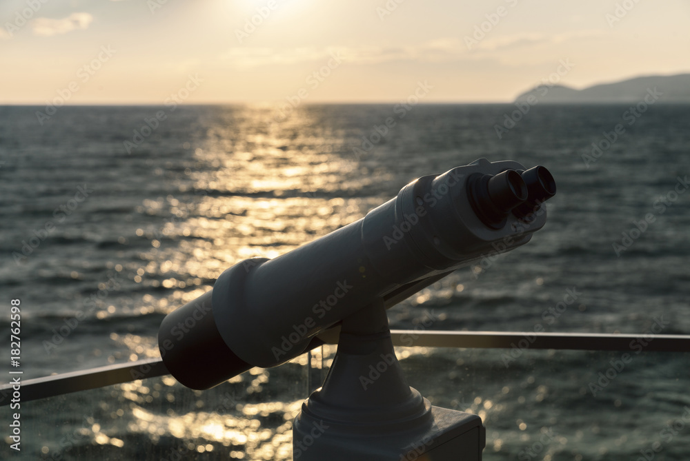 Obraz premium binoculars against the sunset