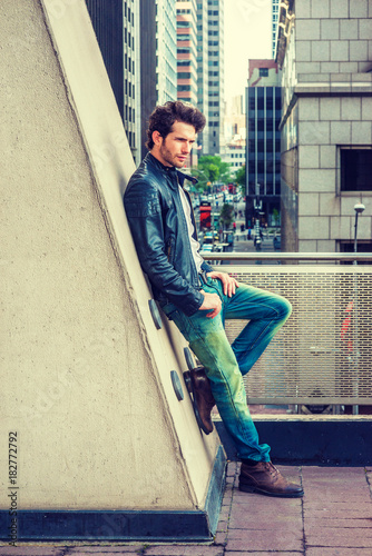 Man Urban Casual Fashion. Wearing black leather jacket, blue jeans, brown  boot shoes, a young guy with beard, leaning against wall on balcony, facing  street, thinking. City Boy. . Photos | Adobe Stock