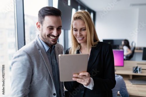 Attractive business couple using tablet in modern office