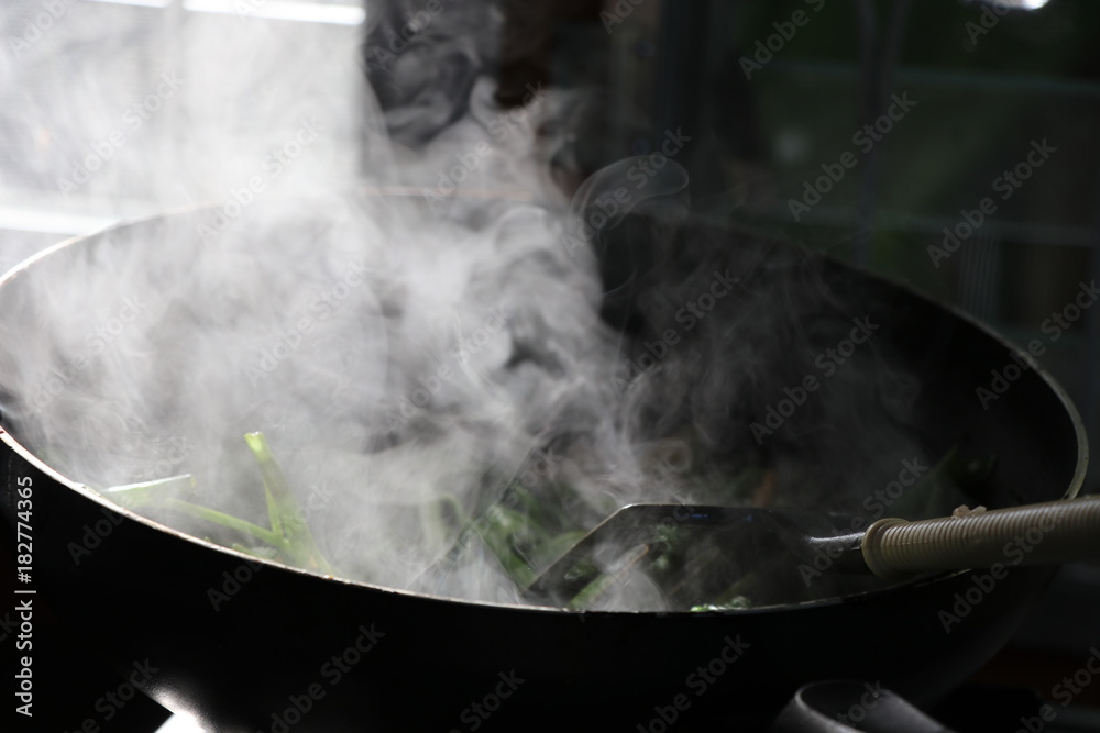 Fried morning glory in hot pan, Thai food with smoke Fried morning glory in hot pan, Thai food with smoke