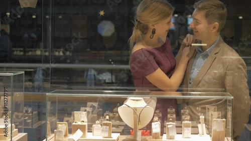 A jewelry store. A young couple is looking at jewelry.