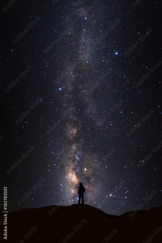 Naklejka premium Landscape with milky way, Night sky with stars and silhouette of man standing on high moutain