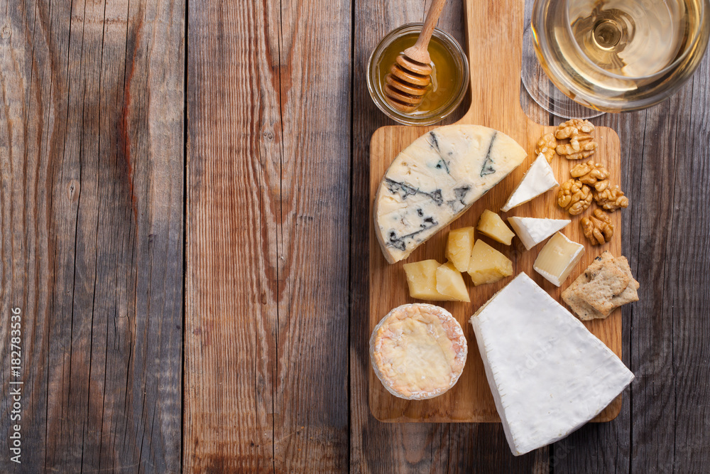 Tasting cheese dish on a wooden plate. Food for wine and romantic, cheese delicatessen on a wooden rustic table. Top view with copy space Tasting cheese dish on a wooden plate. Food for wine and romantic, cheese delicatessen on a wooden rustic table. Top view with copy space