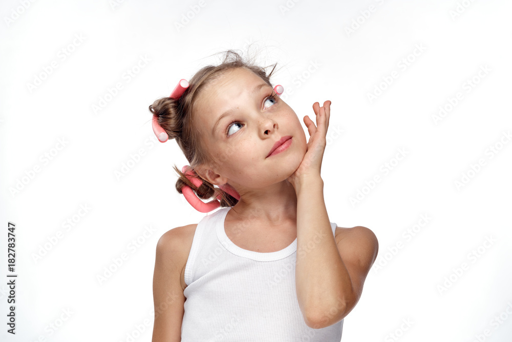 cute girl with hair curlers on her head looking up against a light background, dreaming, hairstyle, beauty cute girl with hair curlers on her head looking up against a light background, dreaming, hairstyle, beauty