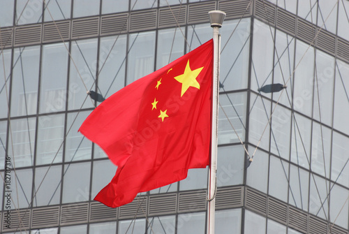 Waving national flag of China in front of building