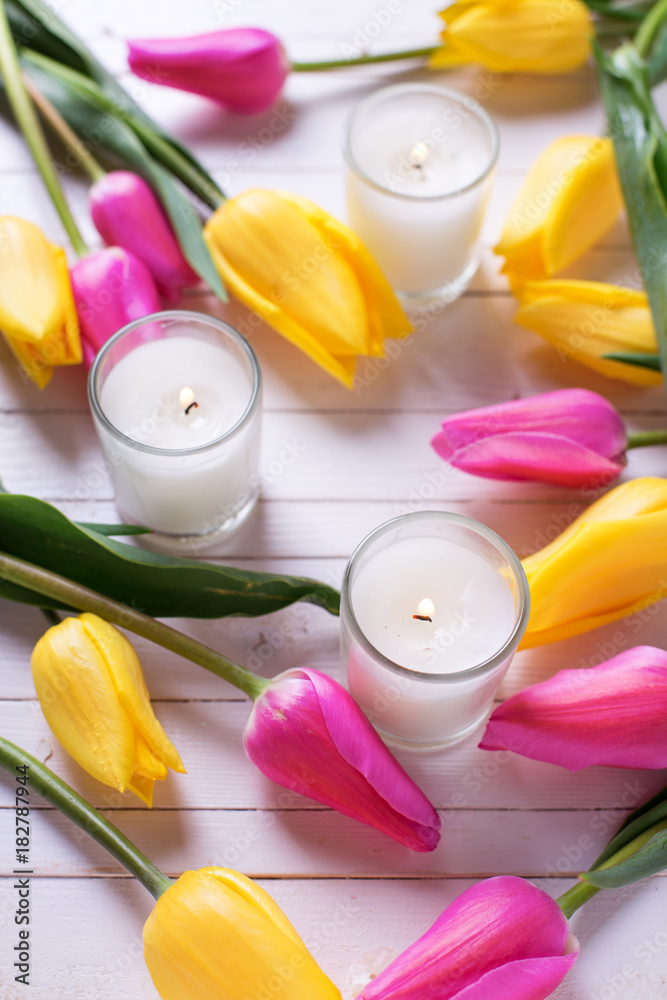 Bright pink and yellow tulips  flowers and candles