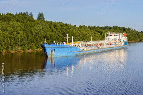 The tanker near the shore of the river