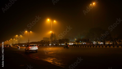 Driving at night on a busy road in New Delhi covered with dence fog