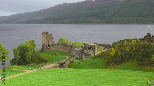 Ruins of a Scottish Castle and Tourists on the Lake