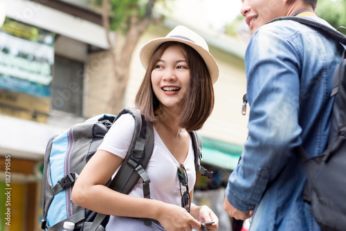 Smiling young Asian couple tourist backpackers