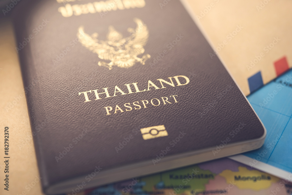 Close up of Thailand passport, brown cover, on the map and document Close up of Thailand passport, brown cover, on the map and document