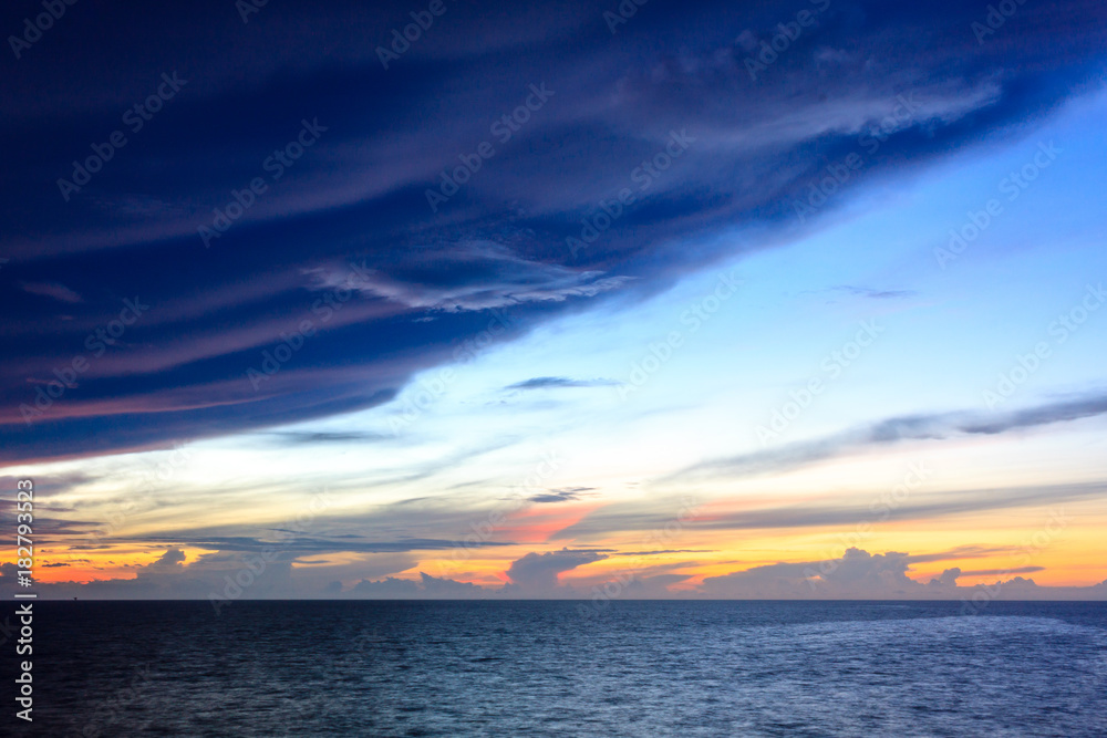 Blue sea and sky with sun red light in the middle sea