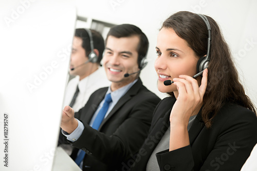 Female telemarketing customer service agent working with her team in call center