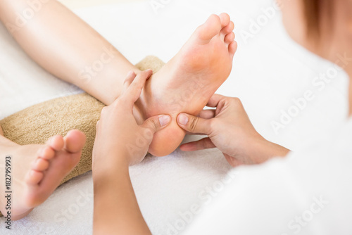 Bilde på lerret Therapist giving relaxing reflexology Thai foot massage to a woman in spa