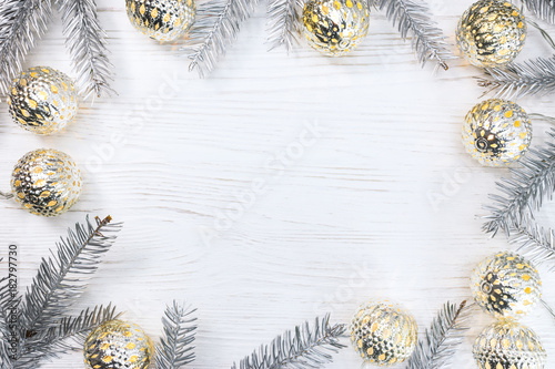 silver christmas tree branches decorated with glowing light garlands on white wooden table. holiday background  flat view.