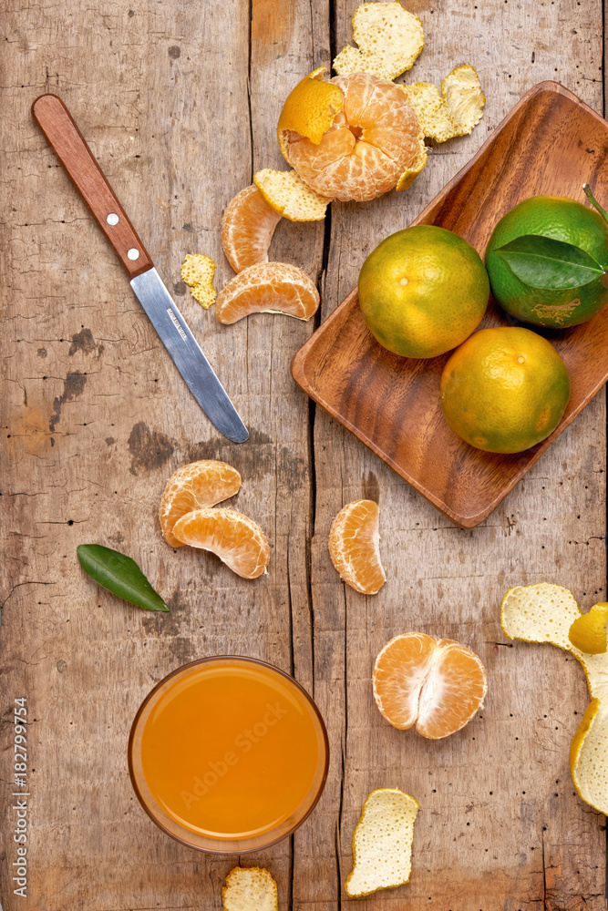 Glass of tangerine juice and fresh peeled fruits Glass of tangerine juice and fresh peeled fruits