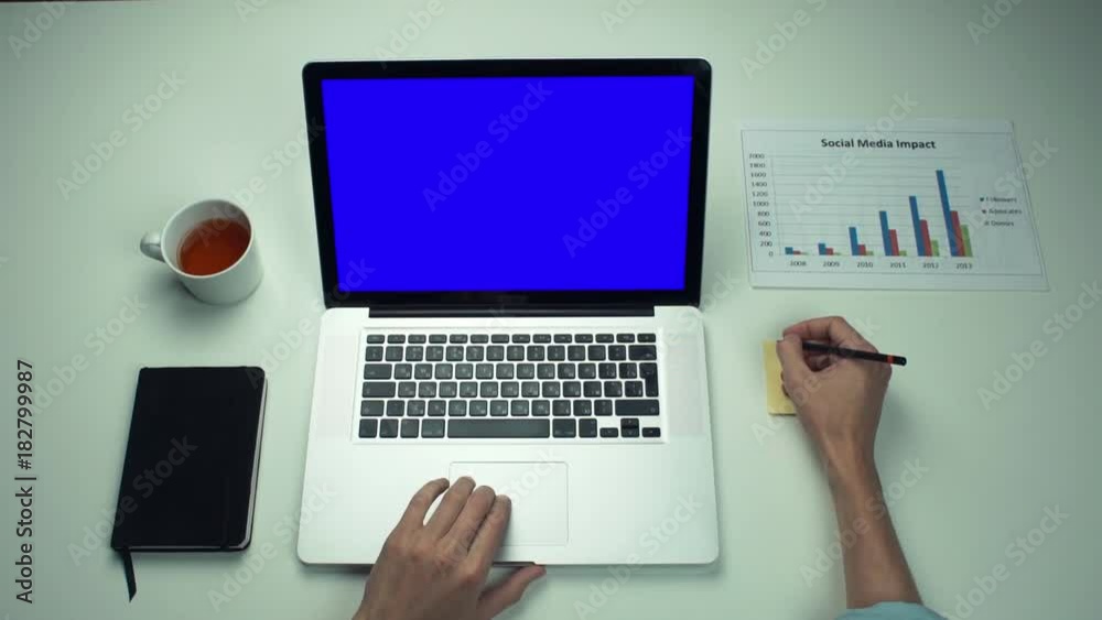 Top view male hands using sticky notes and laptop with green screen Top view male hands using sticky notes and laptop with green screen