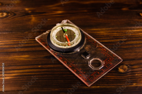Touristic magnetic compass on wooden table