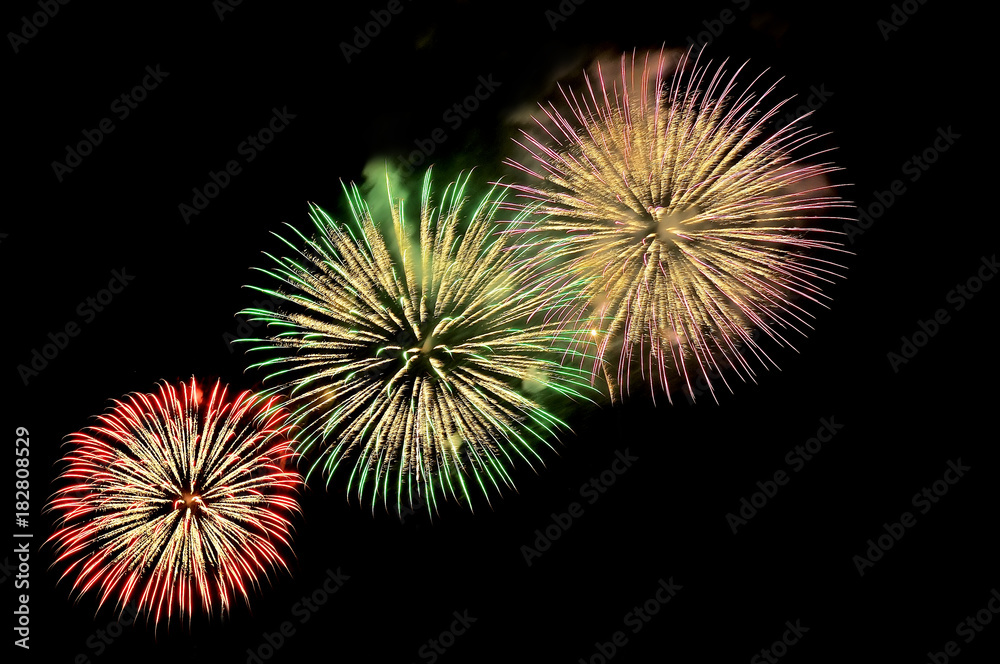 Flashes of fireworks of green, red, purple and gold color