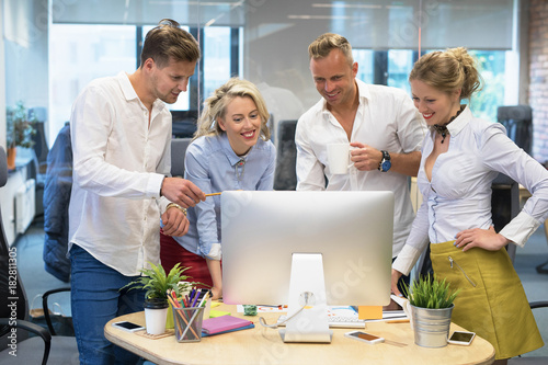 Group of people in office looking at computer