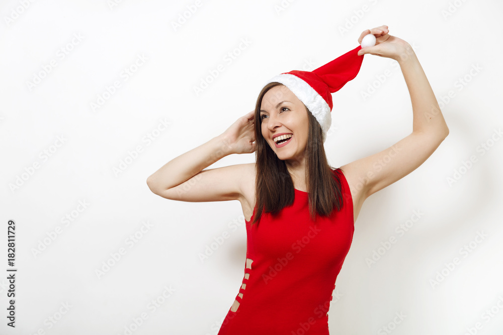 Beautiful caucasian young happy woman with healthy skin and charming smile wearing red dress holding Christmas hat on white background. Santa girl isolated portrait. New Year holiday 2018 concept Beautiful caucasian young happy woman with healthy skin and charming smile wearing red dress holding Christmas hat on white background. Santa girl isolated portrait. New Year holiday 2018 concept