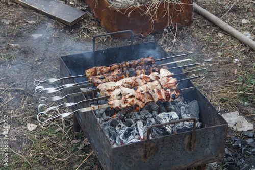 Two young men ignite the wood in the grill, going to fry a shish kebab. photo