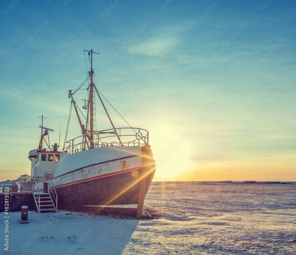 Old fisherman boat in Iceland in grunge colored design Old fisherman boat in Iceland in grunge colored design