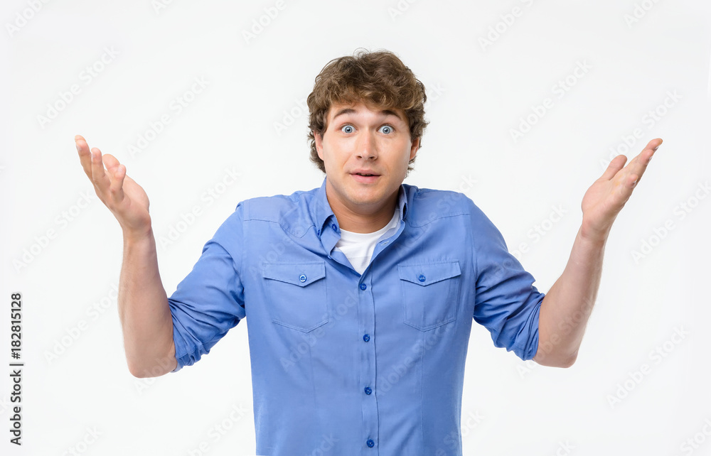 Surprised expression. Man is an emotion of surprise in a blue shirt on a white background. Surprised expression. Man is an emotion of surprise in a blue shirt on a white background.