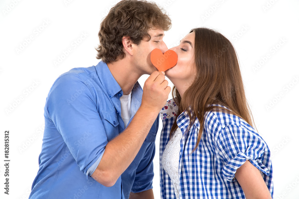 Kiss. Young loving couple holding in their hands red hearts, a symbol of love. Valentine's Day. Kiss. Young loving couple holding in their hands red hearts, a symbol of love. Valentine's Day.