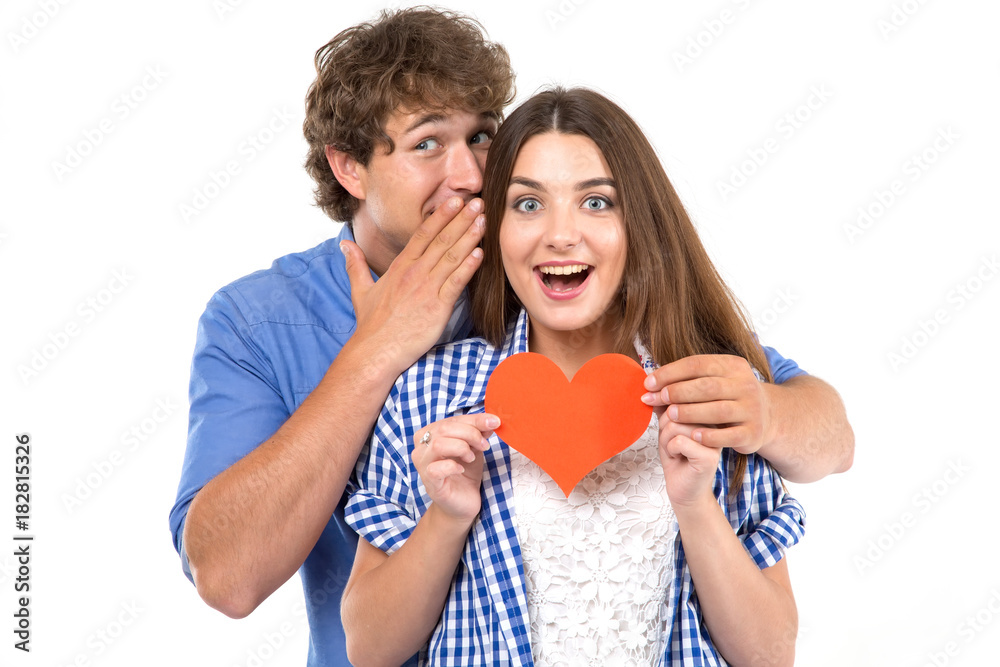 Secret. Young loving couple holding in their hands red hearts, a symbol of love. Valentine's Day. Secret. Young loving couple holding in their hands red hearts, a symbol of love. Valentine's Day.