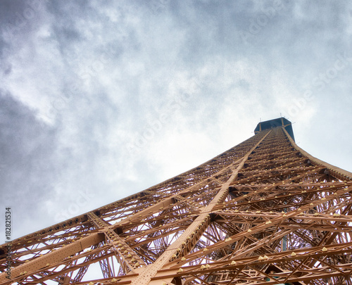 Eiffel Tower top structure, skyward view on a cloudy day - Paris, France