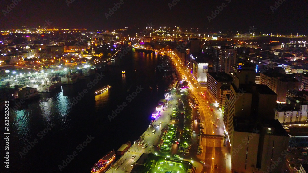 Fantastic nighttime skyline with illuminated skyscrapers. Elevated view of downtown Dubai, UAE. Colourful travel background. Beautiful view of the Dubai night with lanterns, the river and nightlife