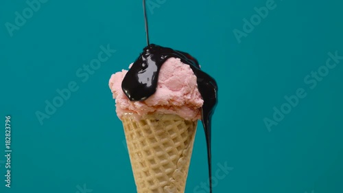 Rotating strawberry ice cream in cone with chocolate sauce