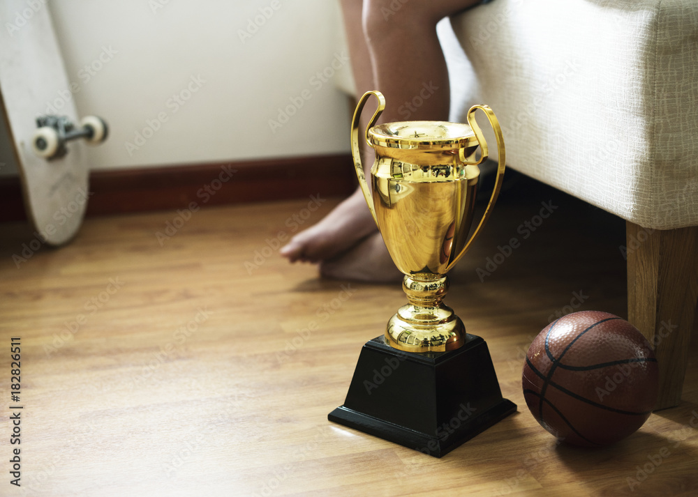 Fototapeta premium Closeup of trophy on the bedroom floor with basketball